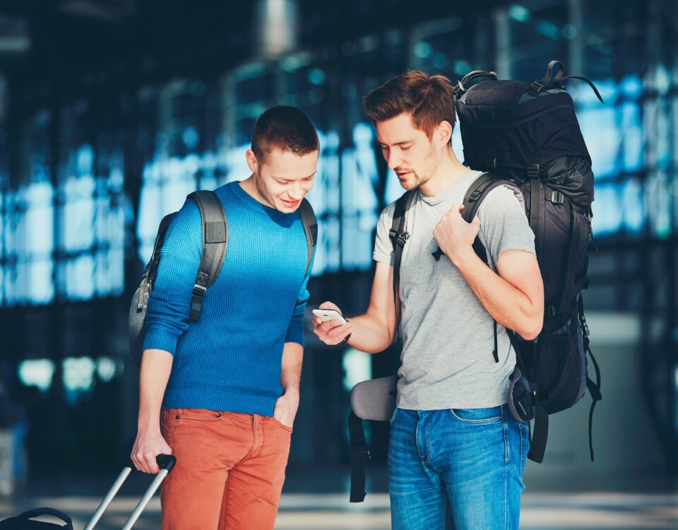 Two friends utilizing a digital mapping platform at the airport.