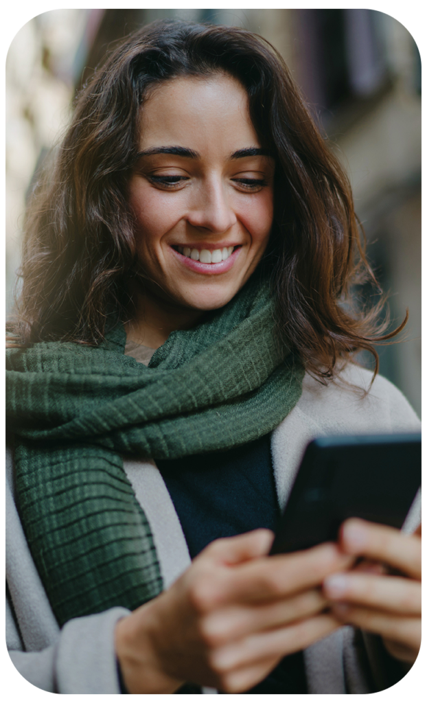 Woman Smiling and Using Phone