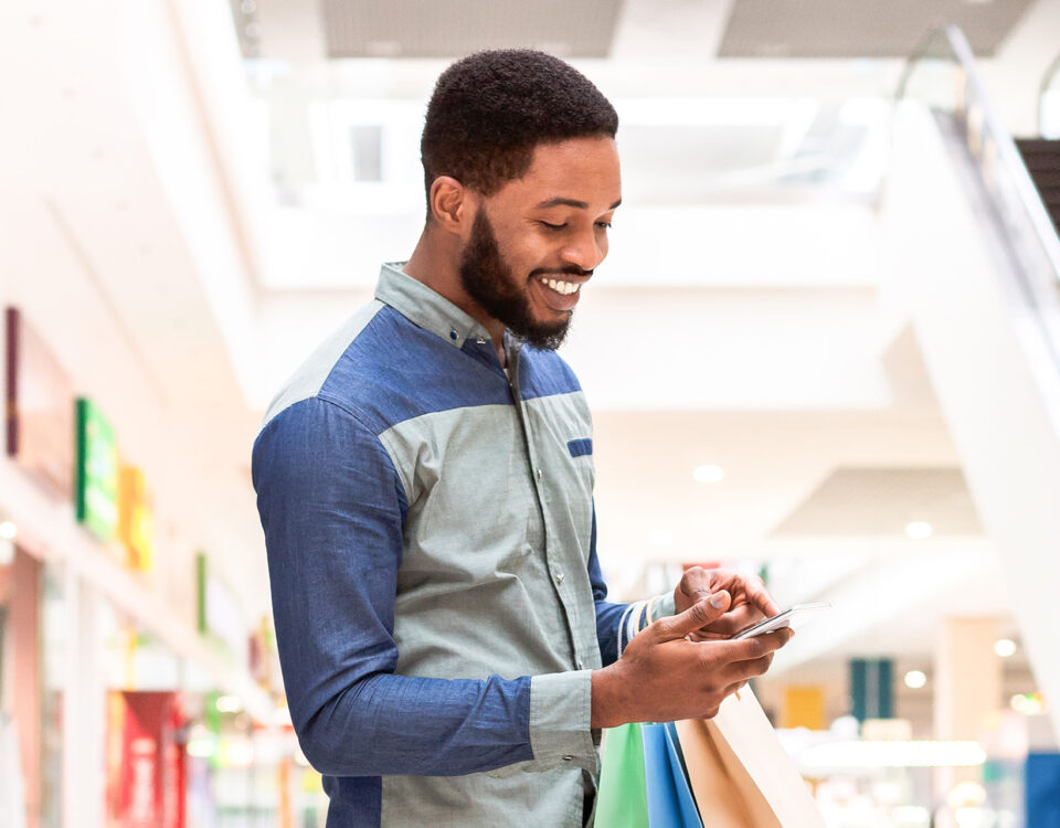 happy man shopping and looking at his phone
